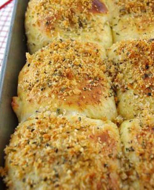 Overhead view of baked Parmesan Dinner Rolls in a metal baking pan.