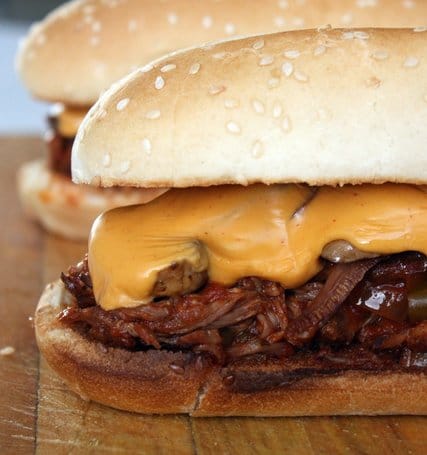 Prepared Slow Cooker Spicy Southwest Steak covered with cheese, on a sesame hoagie roll.